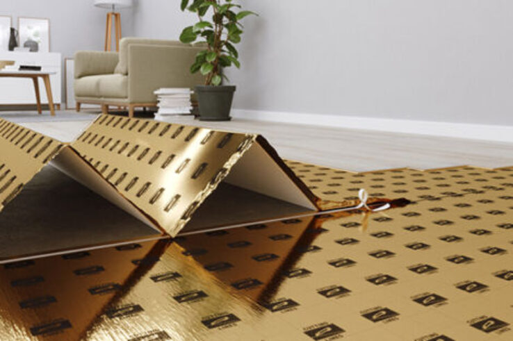 Een vloer met gouden isolerende ondervloer voor PVC-vloeren in een woonkamer, klaar om de vloer te leggen. De ruimte heeft een moderne uitstraling met een minimalistische inrichting.
