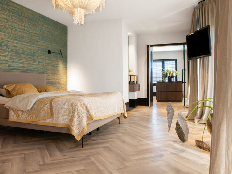 Lichte eiken PVC-vloer in een stijlvolle slaapkamer met een comfortabel bed, moderne verlichting en een warme sfeer.