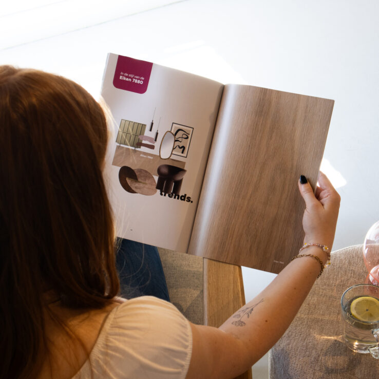 Vrouw bladert door de Vivafloors brochure 2024