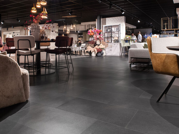 Donkere PVC-tegelvloer in een moderne commerciële ruimte met stijlvolle meubels en een industriële uitstraling.