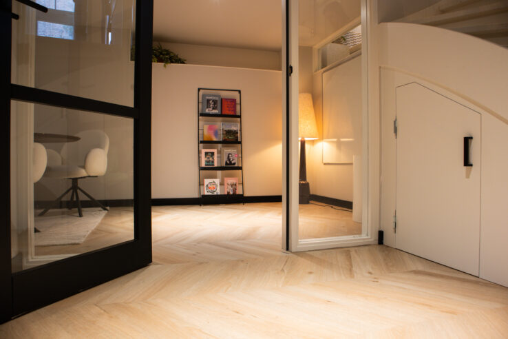 PVC hongaarse punt vloer in een moderne kantoorruimte met zachte verlichting en minimalistische inrichting.